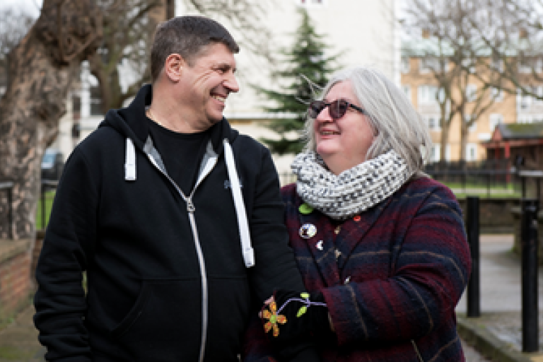 Picture of white man and while woman in a residential street. They are looking at each other. 