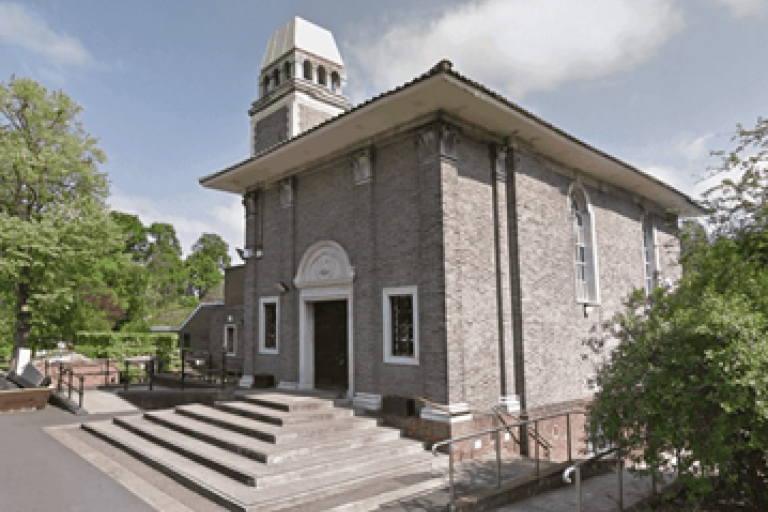 Grey crematorium building with stairs leading to entrance