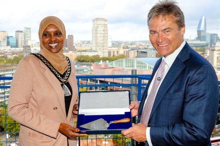 Cllr Naima Ali, Mayor of Southwark and Rick de Blaby, Get Living CEO, posing on top of the building with a trowel