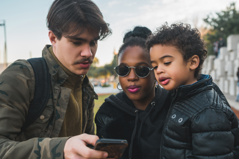 Portrait of a family using a mobile phone in the park