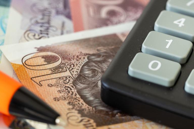 Bank notes, a calculator and a pen