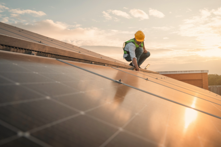 image of rooftop solar panels with workman making adjustments