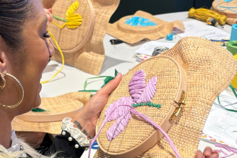 Woman at a workshop working on her raffia embroidery