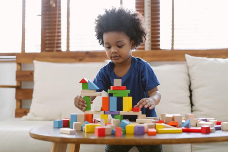 Photo of young boy playing with toy construction blocks