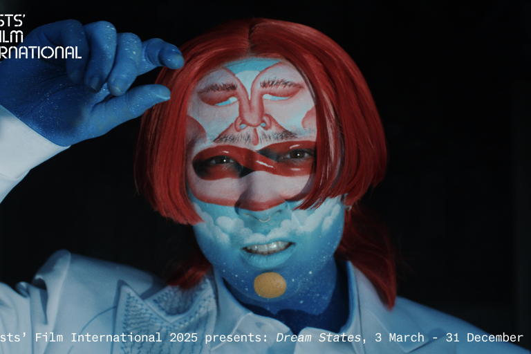 A close up of the artist artistically painted in blues and reds.