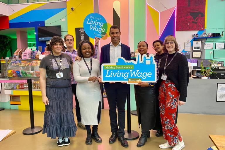 Cllr Batteson holding a living wage employer sign