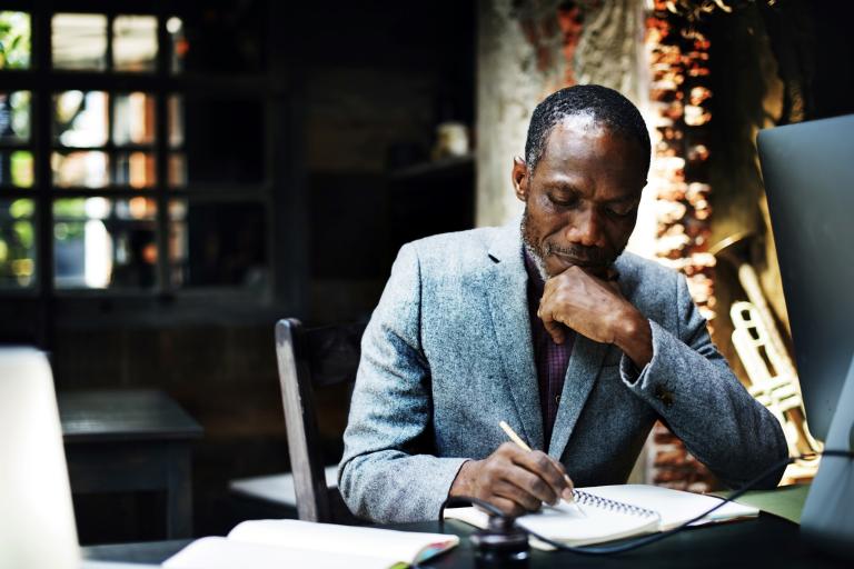 Black man writing in notebook