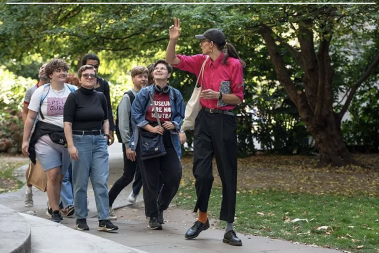 Group of people in the park being led by a guide in red shirt