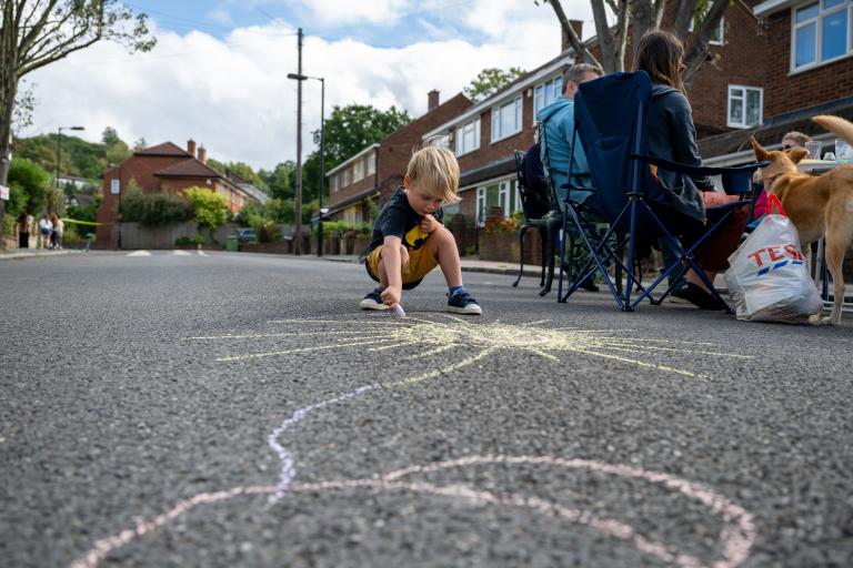 A child drawing with chalk on the road