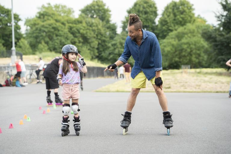 An adult and child roller skating 