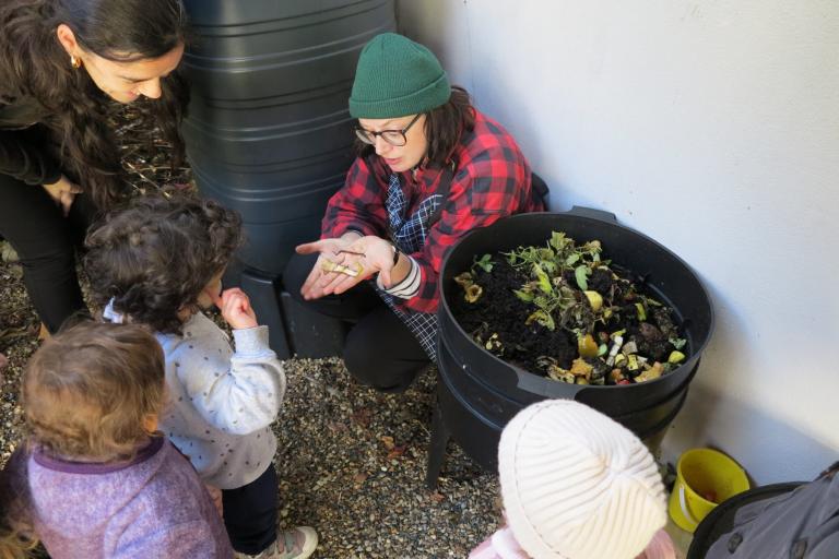 Gardener teaching how to make compost to children