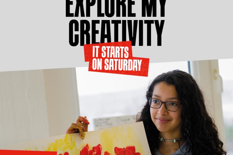 A girl holds up a painting of red flowers on a yellow background