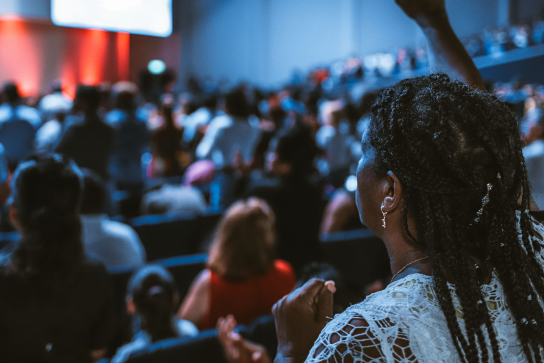 A group of people sitting in conference style setting listening to a talk