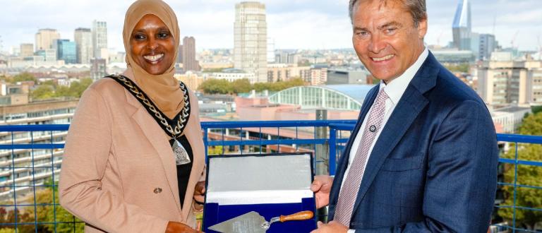Cllr Naima Ali, Mayor of Southwark and Rick de Blaby, Get Living CEO, posing on top of the building with a trowel