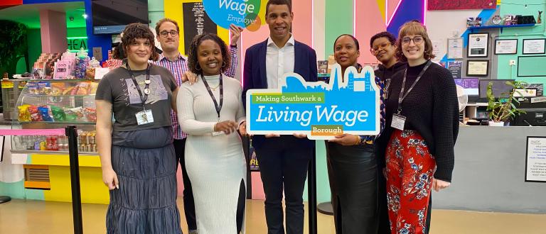 Cllr Batteson holding a living wage employer sign