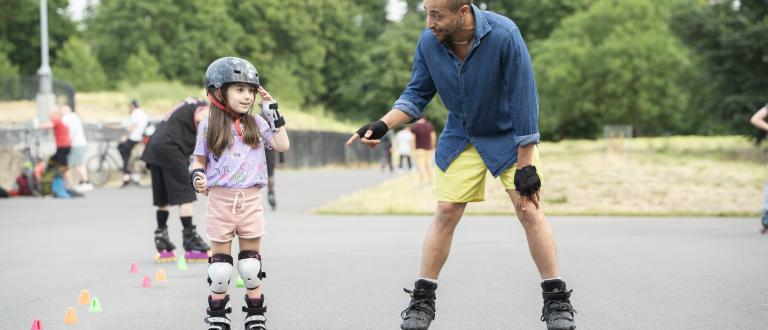 An adult and child roller skating