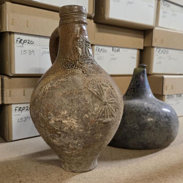Two bottles in front of archive boxes