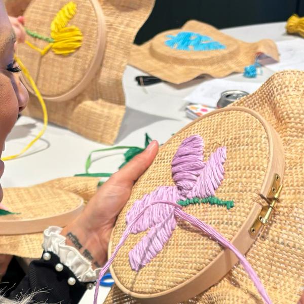 Woman at a workshop working on her raffia embroidery
