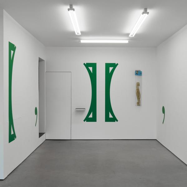 A gallery with green paintings on the wall