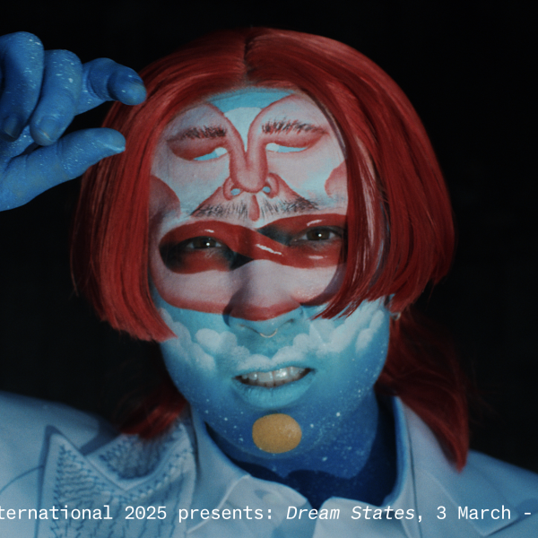 A close up of the artist artistically painted in blues and reds.