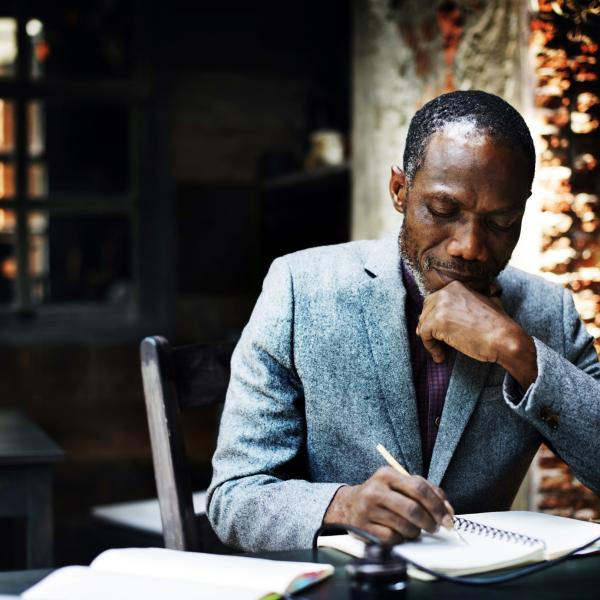 Black man writing in notebook