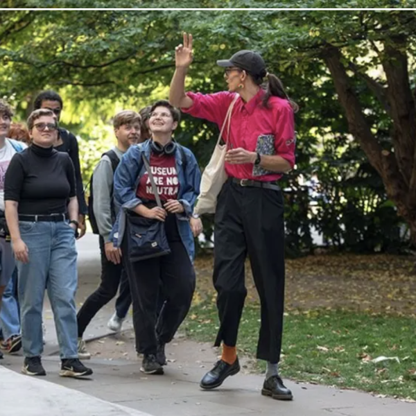 Group of people in the park being led by a guide in red shirt