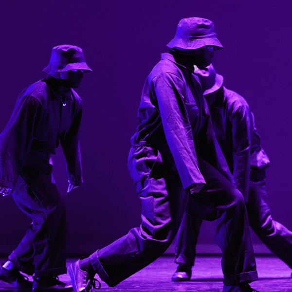 Three hip-hop dancers on a stage.