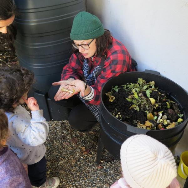 Gardener teaching how to make compost to children