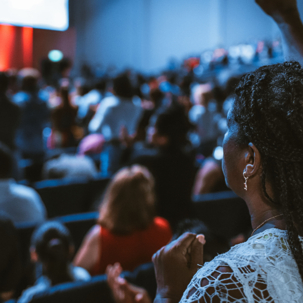 A group of people sitting in conference style setting listening to a talk